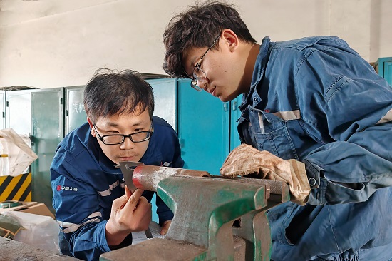 維護部鍋爐專業主管正在檢查指導青工閥門檢修練習要點。 - 副本.jpg